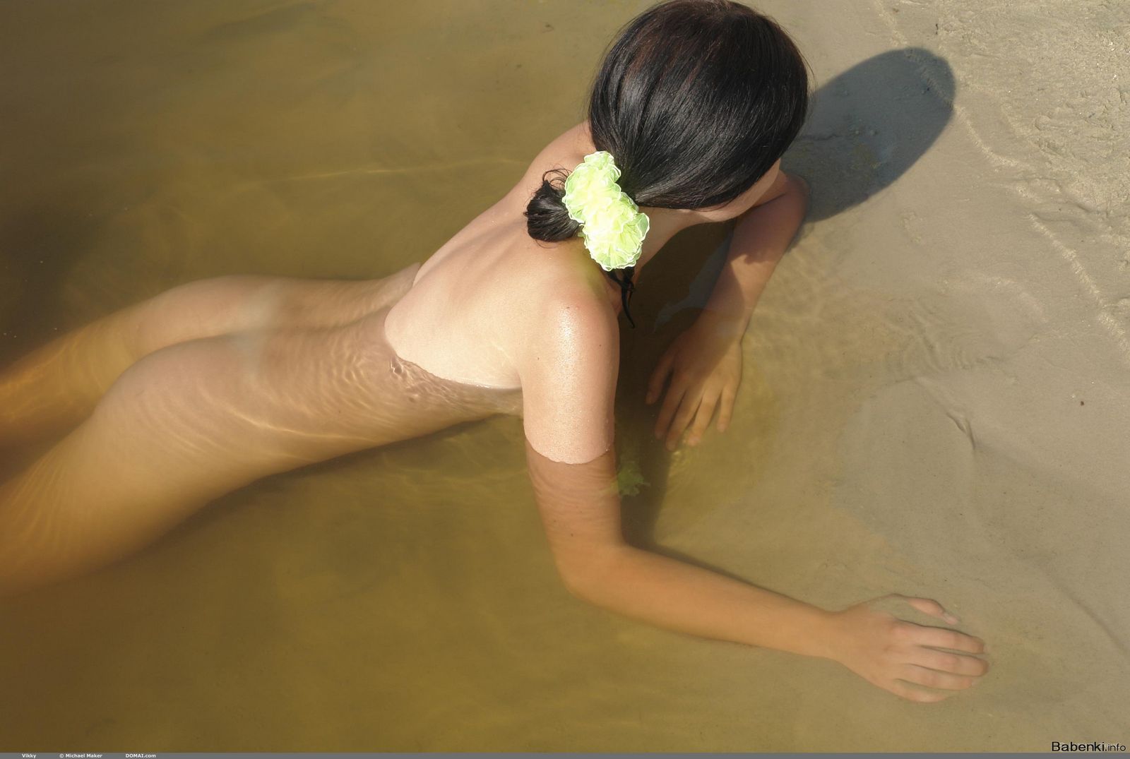 На пляже загорает и купается голышом стройная дама