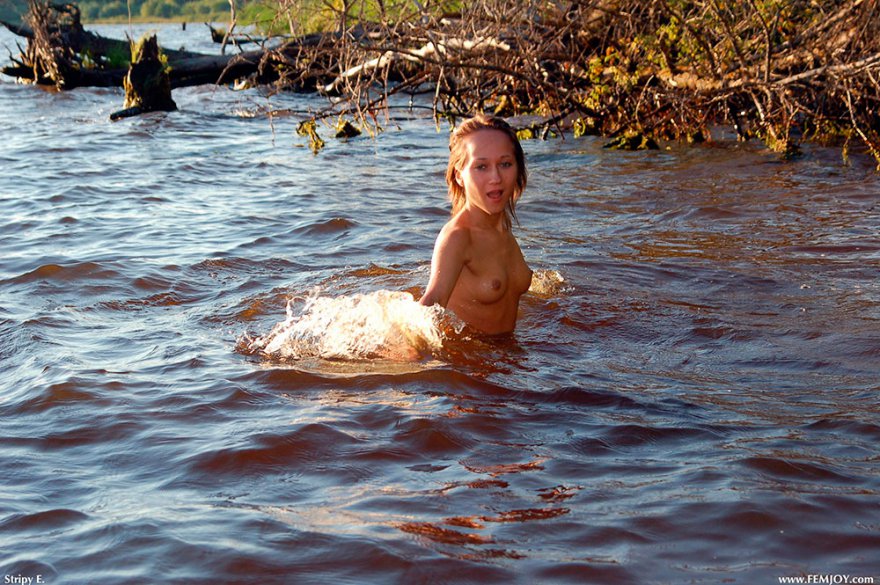 Голая девушка купается в реке