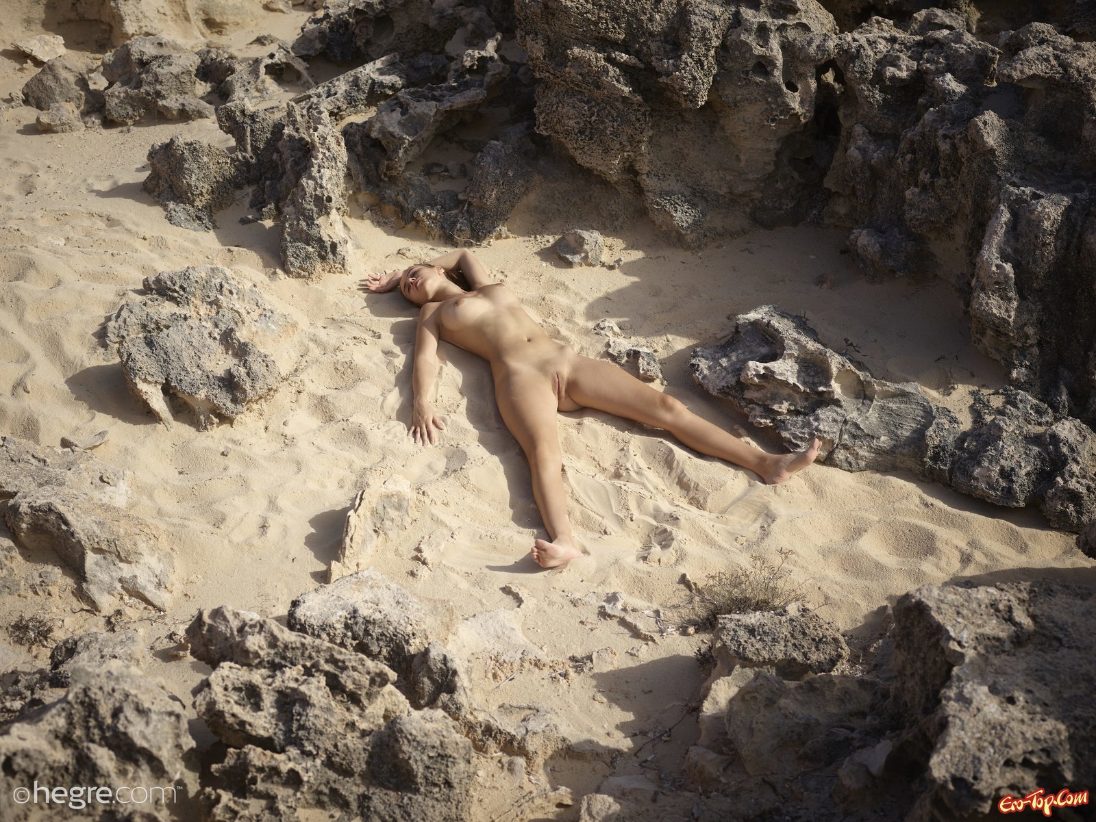 Голенькая девушка с сексуальной внешностью на песке